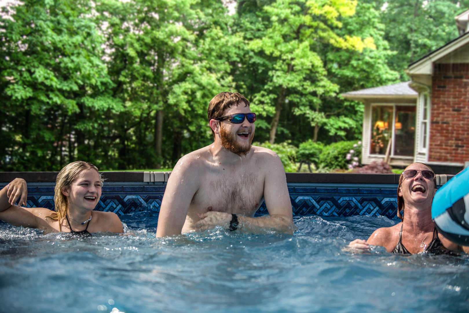 Family smiling in above ground pool